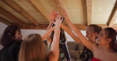 Bir grup arkadaş mezuniyetlerini kutluyorlar. Mezuniyet şapkası takıyor ve diplomasını tutuyor..