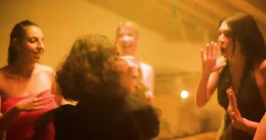 Dört arkadaş bir partide dans ediyor, müziğin tadını çıkarıyor, renkli ışıklar ve birbirlerine eşlik ediyorlar..