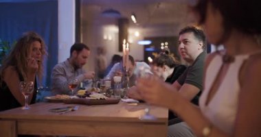 Dostlar sıcak bir akşam yemeği için toplanır. Sıcak, davetkar bir atmosferde mum ışığında sohbet, yemek ve içeceklerin tadını çıkarırlar..