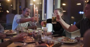 Dostlar lezzetli bir yemek için toplanır, kadehlerini kaldırır birlikte ve neşeyle kadeh kaldırırlar..