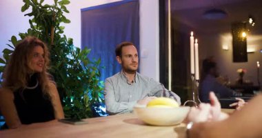 Dört meslektaş bir masanın etrafında toplanır ve gece modern bir ofis ortamında iş görüşmesi yaparlar..