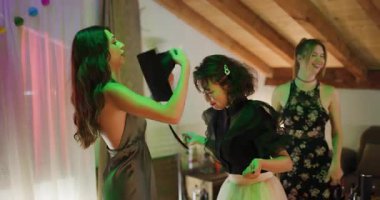 Üç genç kadın mezuniyeti kutluyor. Bir arkadaşım mezuniyet şapkasını arkadaşının kafasına takıyor. Gelecek için mutlu ve heyecanlılar..