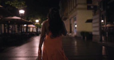 Zarif elbiseli genç bir kadın geceleri ıssız bir caddede yürüyor. Gizem ve gece macerası hissi uyandırıyor..