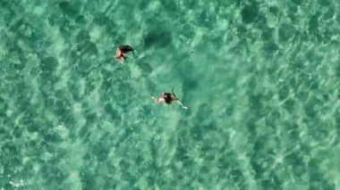 İki kadın güzel turkuaz okyanus suyunda yüzmekten zevk alır. Havadan yukarıdan aşağıya görünüm.