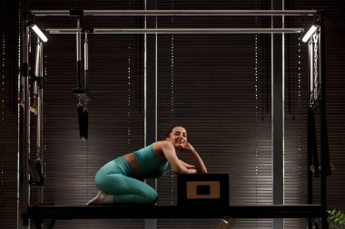 Pratisyen, iyi ışıklandırılmış bir stüdyoda yenilikçi bir pilates makinesiyle karşılaşır. Oturumda çekirdek kuvveti ve esneklik eğitiminin yanı sıra sakinleştirici bir atmosferi desteklendiği vurgulandı.