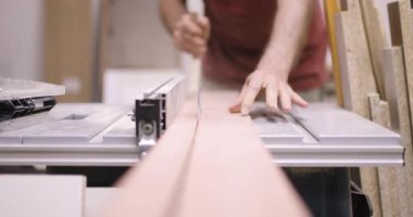 Usta marangoz becerikli marangozluk teknikleri sergiliyor, öğleden sonraları düzenli bir atölyede çalışırken titizlikle ahşap parçaları kesiyor..