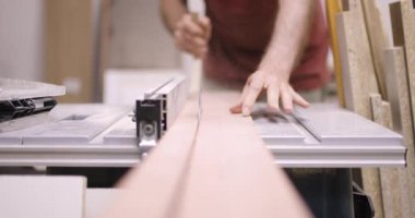 Marangozluk teknikleriyle uğraşan bu adam, bir atölyede özenle çalışan bir zanaatkârı sergiliyor. Ayarlar, bir proje için araçları ve odunların dikkatle manipüle edilmesini vurgular.