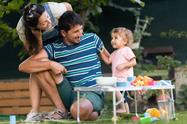 Açık havada birbirine bağlanan bir aile, güneşli bir günde ebeveynler ve çocuklarının oyuncaklarıyla oynaması, aşkı ve mutluluğu simgeliyor..