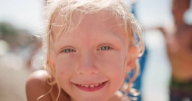 Islak Saçlı, Komik Yüzler Yapan, Sevimli Genç Sarışın Kız 'ın Yakın Çekimi, Ve Deniz kenarındaki güneşli bir sahilde, Yaz tatilinin tadını çıkarırken,.