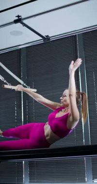 Yetenekli bir jimnastikçi, yerel bir tesiste sabah antrenmanında etkileyici bir güç ve çeviklikle aletler üzerinde yeteneğini sergiliyor..