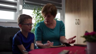 Büyükannem ve torunum ev ödevi ya da ev ekonomisi üzerinde birlikte çalışıyorlar. Aile birbirine yardım eder, birlikte öğrenir ve birlikte olmaktan mutlu olur..