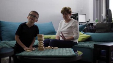 Büyükannem ve torunum evde oyun oynuyorlar. Kanepede oturup yapı taşlarıyla oynuyorlar..