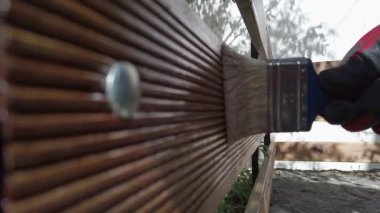 Hamile gemi zemininden yapılmış çit boyama eldiveni. Marangoz koruyucu cila katmanı uyguluyor..