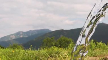 Sersemletici dağlar ve geniş mavi bir gökyüzü tarafından çerçevelenmiş iken, yemyeşil musluk çimlerinin üzerinde süzülerek, canlı bir nehir kaynağından nazikçe akar. Huzurlu bir sahne, doğal güzellikleri gösteriyor..