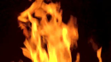 Bacada ateş yanıyor. Karanlıkta soyut ağır çekim alevleri.