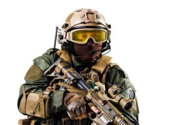 Savaş teçhizatlı bir taktik askeri tüfeği doğrultuyor. Detaylı görüntü, harekete hazır bir askeri ajanın profesyonel ekipman, kask ve ihtiyatlı duruşunu vurguluyor..