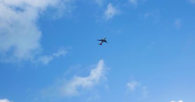 Pofuduk beyaz bulutlarla dolu canlı mavi bir gökyüzünde süzülen bir uçak aşağıdaki manzaranın güzelliğini gözler önüne seriyor. Seyahat ve macera dolu bir an..