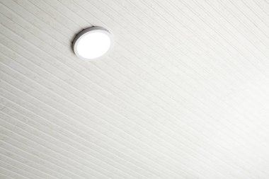 Parlak dairesel ışık beyaz ahşap bir tavana monte edilir. Gündüz vakti modern bir iç mekanın havadar havasını arttırır. Temiz çizgiler ve basitlik sakin bir atmosfer yaratır..