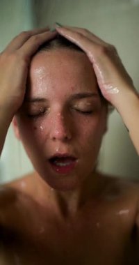 Bir kız, nazikçe kafa derisine masaj yaparken çağlayarak akan suyla ferahlatıcı bir duşun tadını çıkarır. Sakin atmosfer onun huzur ve gençleşme anlarını vurguluyor..