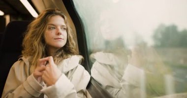 Genç bir kadın trenle güzel bir manzaranın içinden geçiyor. Pencereden bakarken düşüncelere dalmış. Manzara, huzurlu bir ortamda huzurlu bir yolculuğu yansıtıyor..