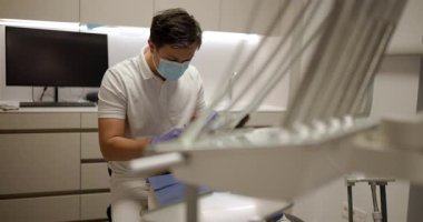 Bir diş hekimi, çağdaş bir klinikte hastaya bakım sağlar. Doktor rahatlık ve güvenliği sağlarken prosedürleri açıklıyor. Araçlar ve teknoloji deneyimi güçlendirir.