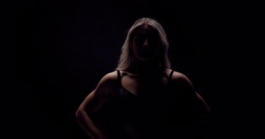 Strong, confident woman flexes muscles in a striking display of power and fitness.