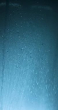 Mesmerizing Water Drops Falling in a Dark Blue Shower Stream, Captured in High Frame Rate Slow Motion, Highlighting Each Pure Droplet for a Tranquil and Refreshing Experience.