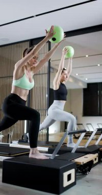 Çağdaş bir fitness stüdyosunda iki kadın zorlu bir antrenman rutinine girişiyor. Hamle yaparken ağırlık kullanırlar, güç ve koordinasyon gösterirler..