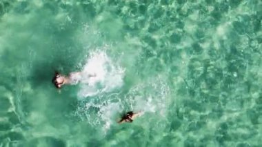 İki kadın güzel turkuaz sularda yüzmekten zevk alır. Arkadaşların tatildeki havadan görünüşü eğleniyor.