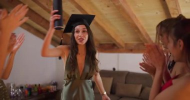 Heyecanlı mezun arkadaşlarıyla kutlama yapıyor, mezuniyet töreninden sonra neşe ve başarıyı paylaşıyor..