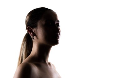 Beyaz arka planda küpe takan at kuyruklu bir kadının silueti. Sakin, zarif ve düşünceli..