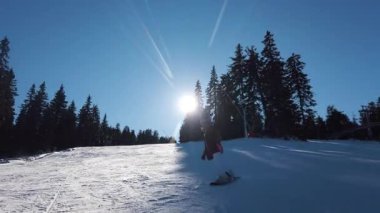 Snowboarder girl enjoying a sunny day on the slopes of Kopaonik, Serbia. Winter sports adventure and freedom.