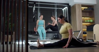 Bir grup kendini adamış birey, çağdaş bir spor salonunda egzersiz ve dayanıklılık egzersizlerine odaklanarak fitness seansına katılıyor. Çevre motivasyon ve refahı teşvik eder..