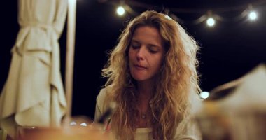 Bu klip, arkadaşlarıyla keyifli bir akşamda dışarıda bir restoranda güzel yemek ve içeceklerin keyfini çıkaran bir kızı gösteriyor..