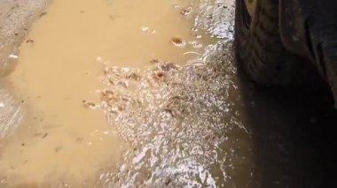 Çamurlu arazide yol alan güçlü bir araba hızlandıkça her yere su ve çamur sıçratıyor. Engebeli manzara off-road macerasına heyecan katıyor..