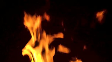 Bacada ateş yanıyor. Karanlıkta soyut ağır çekim alevleri.