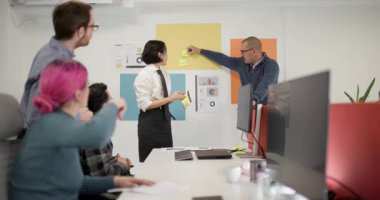 Takım üyeleri fikirleri paylaşmak için bir ofiste toplanırlar. Bir iş kadını ve işadamı, meslektaşları dizüstü bilgisayarları ve notları olan bir projede işbirliği yaparken sohbete rehberlik ediyor..