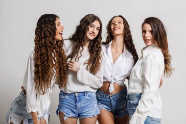 Modaya uygun beyaz bluzlar ve kot pantolonlar giyen dört genç arkadaştan oluşan neşeli bir grup, mutluluk anlarını kahkahalarla paylaşıyorlar, arkadaşlığı, modayı ve birlikteliği gündelik bir fotoşopla temsil ediyorlar.