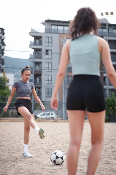 Şehir binalarının yakınında futbol oynayan iki genç kadın, çatışmanın ortasında yakalandı..