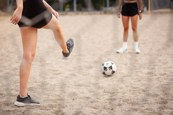 İki bayan oyuncu kumlu bir sahada futbol antrenmanı yapıyor, spor, takım çalışması ve açık hava sporları..