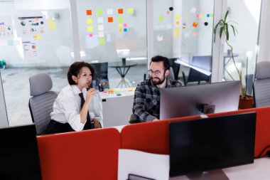 İki iş adamı, canlı bir ofis alanında sohbet edip beyin fırtınası yapıyorlar. Gösterişli ortam, projeler üzerinde birlikte çalışırken yaratıcılığı teşvik ediyor..