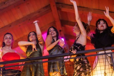 Enerjik genç kadınlar kapalı bir yerde neşeli bir dans seansının keyfini çıkarıyorlar. Gülücüklerini ve sevinçlerini paylaşıyorlar. Arkadaşlığın, kutlamanın ve mutluluğun tasviri.