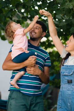 Üç kişilik genç bir aile dışarıda kaliteli zaman geçirir. Doğal ortamlarda neşeli anlar yaratırlar..
