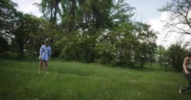 İki bayan arkadaş, ağaçlarla çevrili, yemyeşil bir parkta, boş bir öğleden sonranın keyfini çıkarıyorlar..