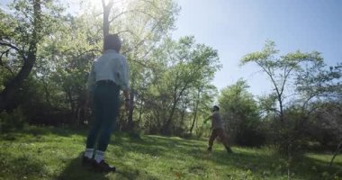 Genç bir çift, güzel bahar güneşinde frizbi oynayarak doğada eğlenceli bir günün tadını çıkarıyor..