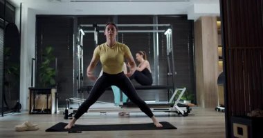 Canlı bir fitness seansına üç kişi katılıyor. Diğerleri birbirini cesaretlendirirken, bir kişi özenle paspasa uzanır. Çevre aydınlık ve motive edici..