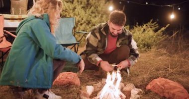 İki arkadaş gece ormanda ateşin başında oturur. Yemek pişirir ve konuşurlar, sıcaklığın ve ışığın tadını çıkarırken anılar yaratırlar. Yıldızlar arka planda parlıyor.