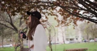 Genç Kız Parktaki Müzikten Kulaklıkla ve Taşınabilir Hoparlörle Hoşlanıyor