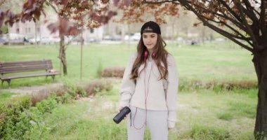 Tasasız Genç Kız Parkta Müzikle Dans Ediyor, Kulaklıkla Açık havada eğleniyor ve Taşınabilir Hoparlörle