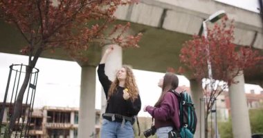 Sırt çantalı iki genç kadın bir şehri keşfederler, fotoğraf makinelerinde fotoğraf çekerler ve seyahat maceralarının tadını çıkarırlar..